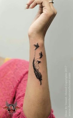 Tatouage plume sur l'avant bras avec trois oiseaux